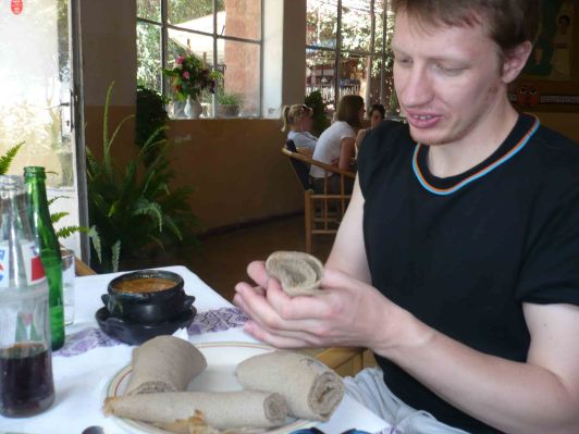 My friend Graham tries some Injera with goat stew.