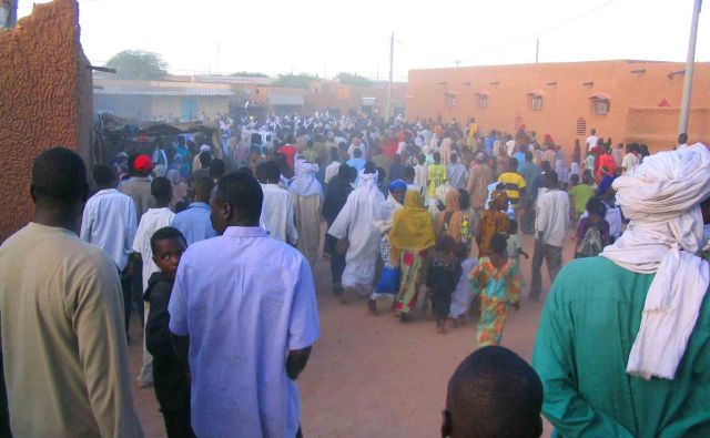 Crowds gather and walk the Agadez streets.