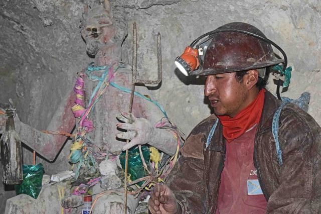 Our guide with a statue of the mine's God, Tio.