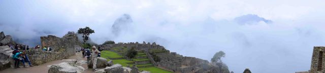 Machu Picchu looks out to many mountains, hideen by the clouds.